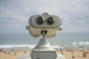 Coin operated binocular on the summer beach, tourist scene in Spain
