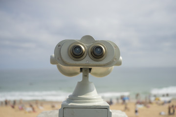 Coin operated binocular on the summer beach, tourist scene in Spain