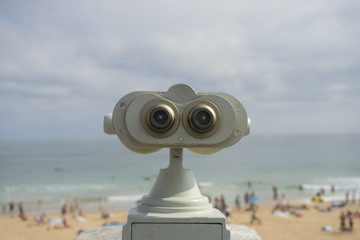Coin operated binocular on the summer beach, tourist scene in Spain