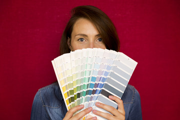 Home improvement. Beautiful women choosing a color from color palette. Renovating a room.