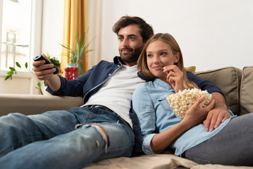 Couple watching TV on a sofa at home