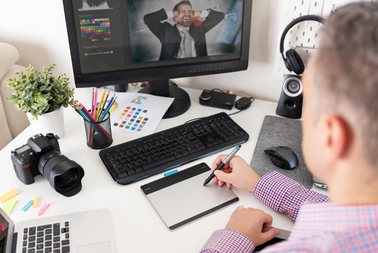 Graphic designer uses a pen and graphic tablet