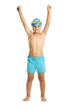 Boy wearing swimming trunks holding his hands up