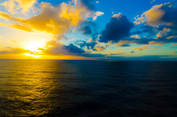 Blue orange sunset on empty peaceful quiet ocean water in pacific atlantic sea for ship cruise family vacation and holiday