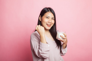 Healthy Asian woman drinking a glass of milk.