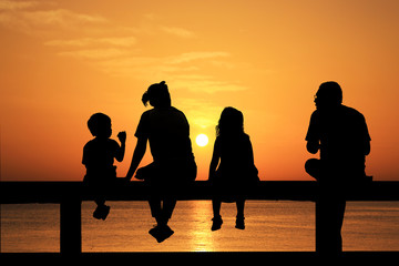 Fototapeta na wymiar silhouette of family on the beach at sunrise time