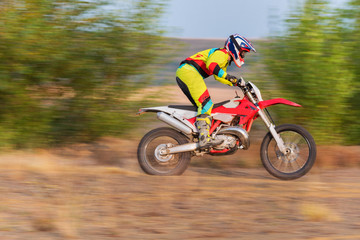 Obraz premium Motocross rider doing a wheelie