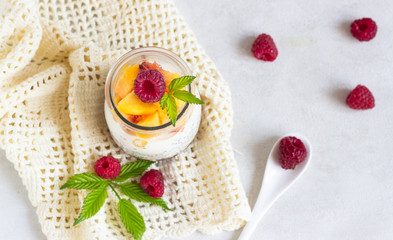 Obraz na płótnie Canvas Vanilla chia seeds pudding in glasses with fresh raspberries and peaches. Healthy dessert breakfast.
