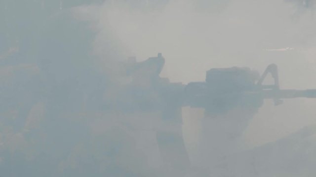 Soldiers are fighting in a trench in a smoky forest