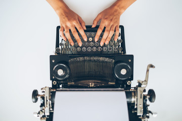 Close up of writer typing with retro typewriter, high angle view