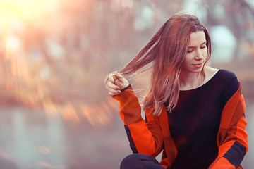 autumn sun rays adult girl outdoor / girl in autumn in a Scottish plaid posing outdoor in a park on a sunny day