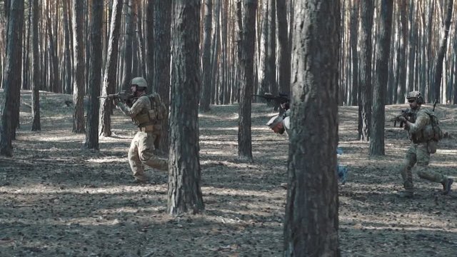 Soldiers escorting captive Mujahideen man in forest