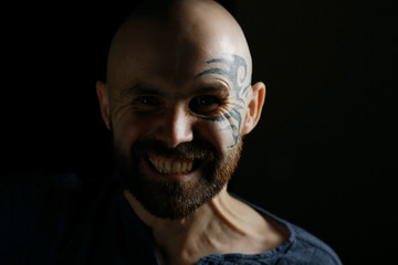tattoo on the face,  man with a tattoo,  brutal bearded guy, studio portrait of a man