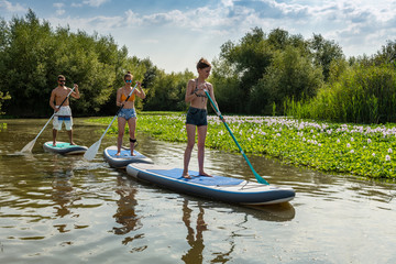 Fototapeta na wymiar Man and women stand up paddleboarding