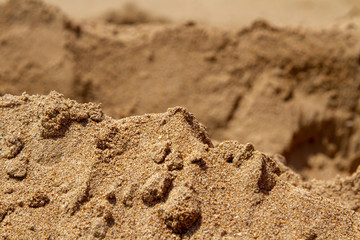 Mountain ranges of sea sand. Reduced model of mountains and rocks from sand. Canyons and cliffs created from sand. The concept of the desert and mountain ranges.