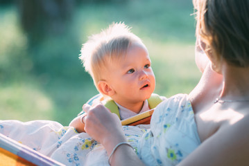 Cute cheerful child with mother play outdoors in park