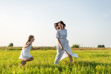 mother and daughter having fun in green meadow together