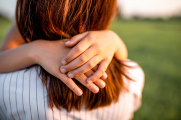 Obraz premium cropped shot of embracing mother and daughter in green meadow