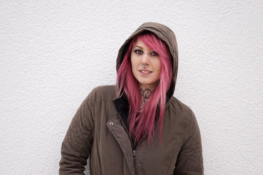 Portrait Of A Young Alternative Woman With Pink Hair Piercings And Tattoos                               