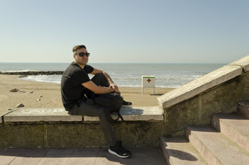 young man walking on the beach on a sunny day