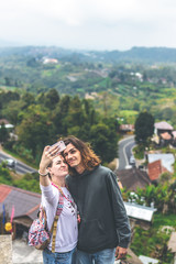 Fototapeta premium Young couple using smartphone together on the nature backgorund. Bali island.