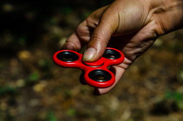 Red fidget spinner in female hand