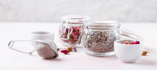 Dried rose flower buds and flowers in glass jars. Herbal tea, cleansing, organic bio products. Banner Concept