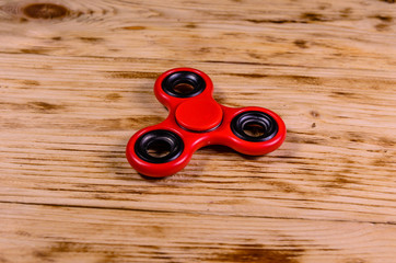 Red fidget spinner on wooden desk