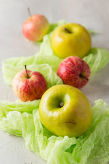 Green and red apples on a light background with a green cloth