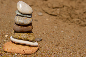 Fototapeta na wymiar Concept: the seven stones in balance, the seven chakras in harmony, the seven senses of man. The concept of balance, harmony, tranquility and purity. Tower of stones on the left edge of the photo.