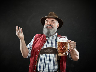 Germany, Bavaria, Upper Bavaria. The smiling man with beer dressed in in traditional Austrian or...