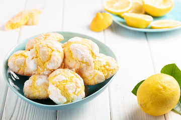 Cracked Lemon cookies in blue plates on white wooden background