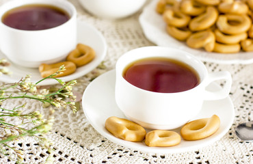 Cup of tea with bagels cookies on rustic serving table