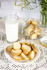 Glass of milk with croutons cookies on rustic serving table