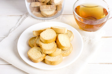 Croutons cookies and cup of tea on rustic serving table
