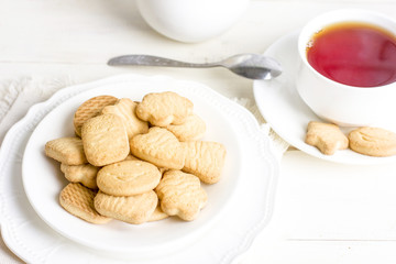 Sugar shortbread cookies in white plate with cup of tea