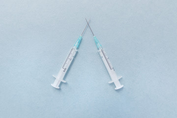 Medical syringes, needles. Two syringes on a blue background