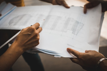 Soft focus of hand three industrial engineer. Engineering working and talking with drawings inspection on building outside. Engineering tools and construction concept.