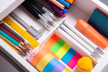 Opened office desk drawer with stationary