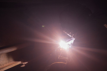 Welder repairs freight car in railway depot