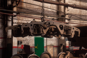 In the workshop for the repair of railway wagons, the wheel carts are assembled by means of a bridge crane