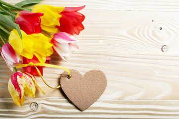 Obraz na płótnie Canvas Colorful tulip flowers and heart shape cards on wooden table background with space for text