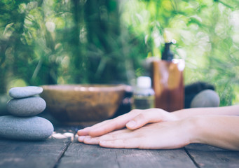 A woman's hand with a stone pyramid on an old wooden table. Japanese style. Simplicity, zen, relax, calm and peaceful mood. Copy space