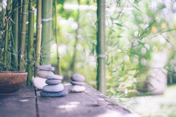 Background with bamboo and stones on an old wooden table. Japanese style. Simplicity, Zen, relax, calm and peaceful mood. Copy space