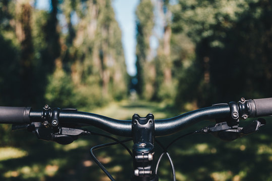 Mountain bike handlebar stem in the park. Point of view