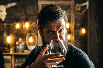 Man drinks brandy or whiskey. Bearded man wearing suit and drinking whiskey brandy or cognac. Sommelier tastes alcohol drink. Drinking and party concept. Degustation and tasting.