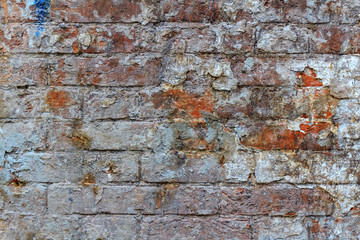 Dirty vintage red brick wall texture with paint stains. Abstract brick wall background