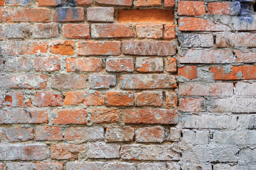 Weathered vintage red brick wall texture with paint stains. Abstract brick wall background