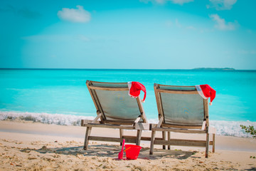 Christmas on beach -chair lounges with Santa hats at sea