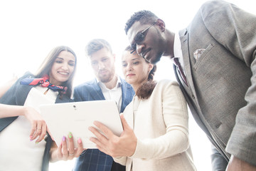 Beautiful business people are using gadgets, tablet, talking and smiling during the conference in office